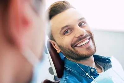 man talking with Dr. Zimmerman after a dental crown restored his smile