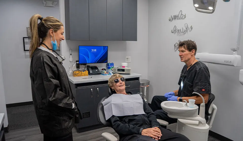 Dr Jay Zimmerman and staff member speaking with a patient in the exam room at Dr Jay Zimmerman Dentistry in Mountainside NJ.